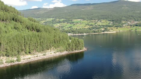 Aerial-reveal-shot-of-a-vast-lake-Tinnsja-in-Norway-Telemark,-on-a-sunny-day