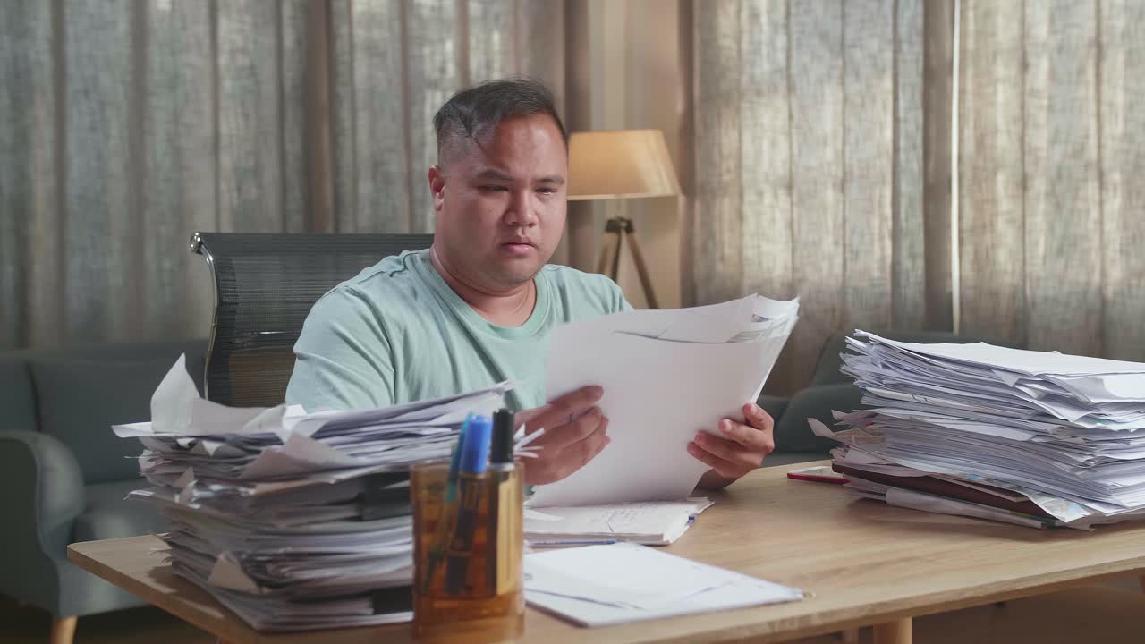 presión hombre gordo asiático cansado trabajando duro con documentos en la oficina