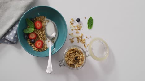 video de cereales y frutas en tazón de cerámica en la encimera blanca de la cocina