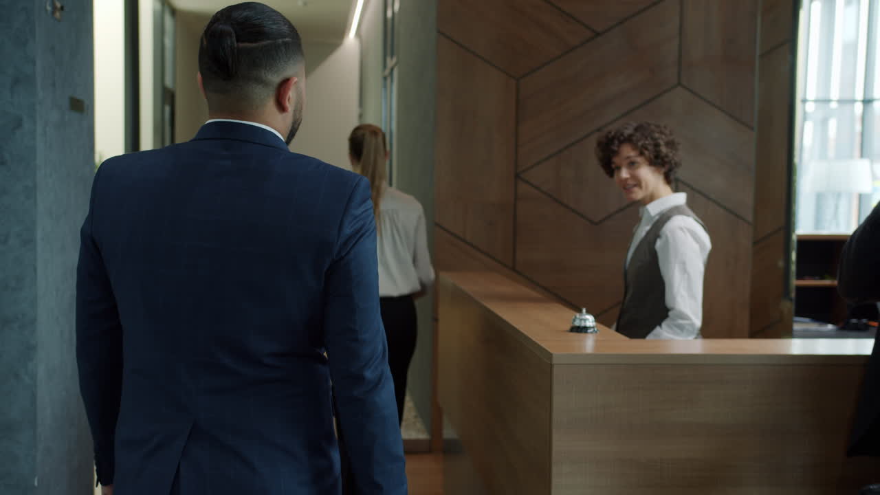 Uomo d'affari che fa il check-in alla reception dell'hotel