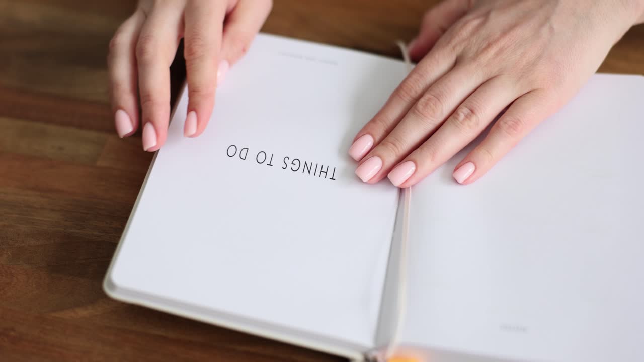 Hands holding a 'Things To Do' notebook