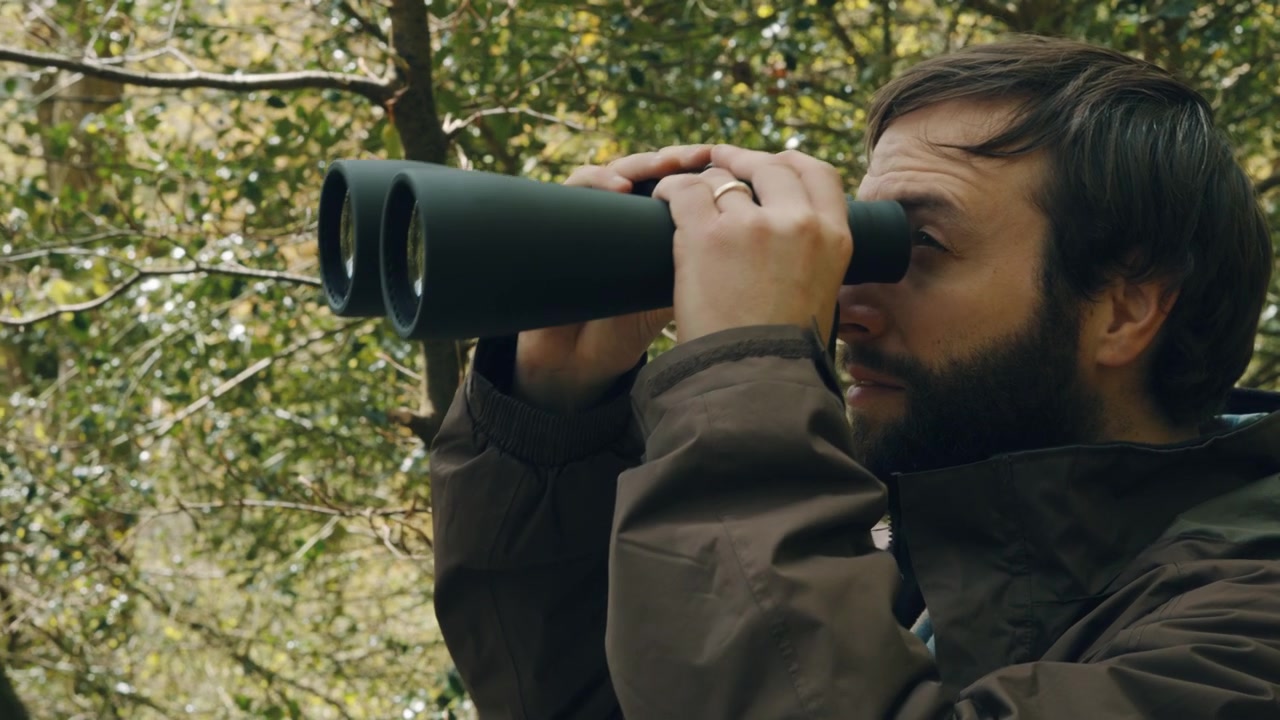Close Up of Birdwatcher Man Searching in Forest Observing Birds and Nature - Slow Motion