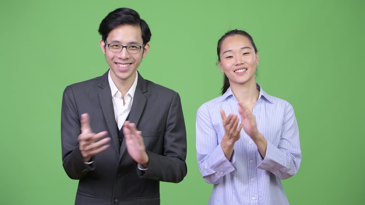 젊은 아시아 비즈니스 커플이 함께 손을 치고 있습니다.