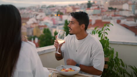 Smiling-family-testing-champagne-at-balcony-vertical.-Pair-toasting-wine-glasses