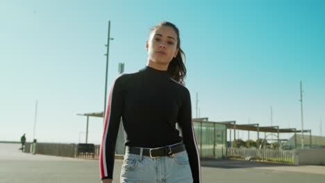 Empowered-Young-Attractive-Latin-Woman-Zoom-in-closeup-medium-shot-looking-straight-to-the-camera-on-a-sunny-day-at-the-city