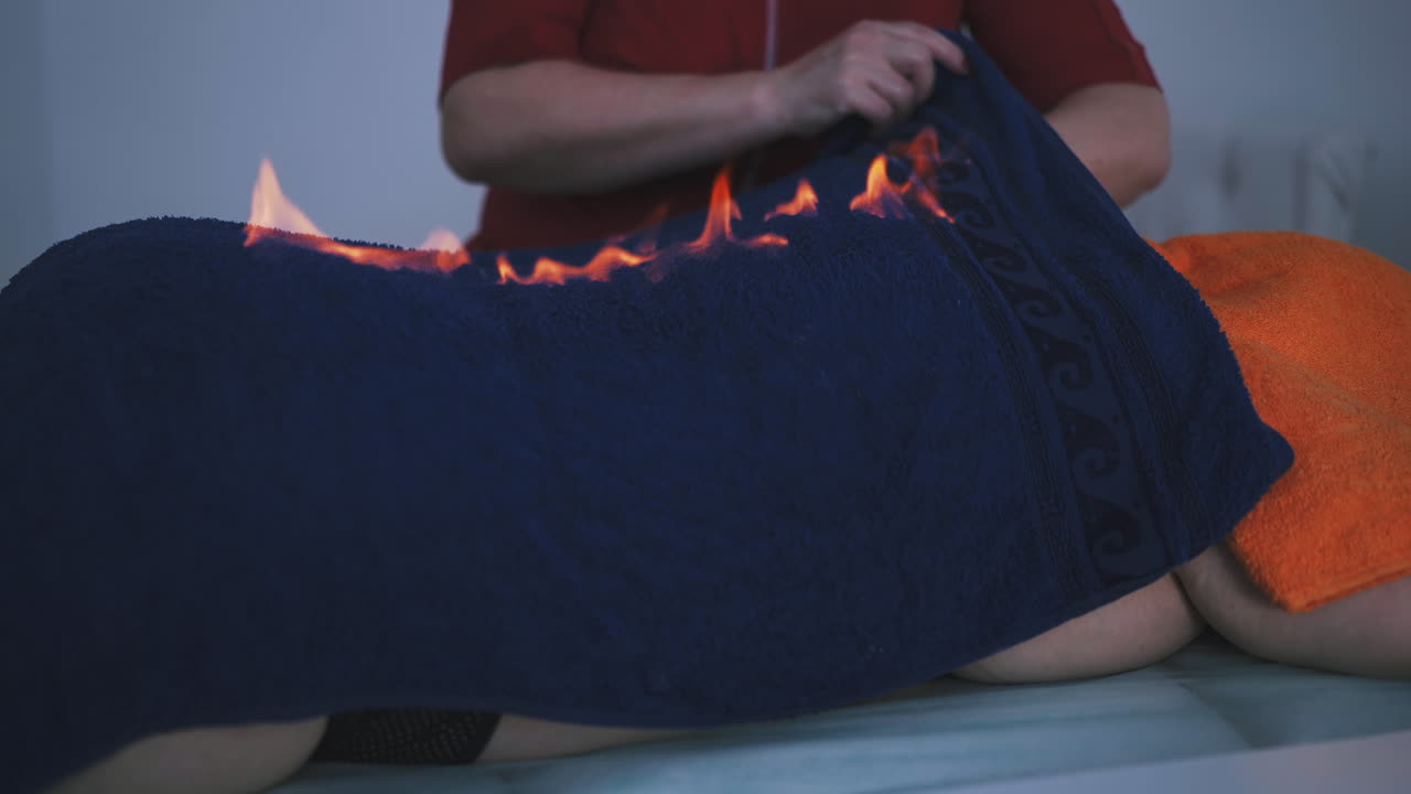 женщина проверяет и борется с огнем на спине пациента с полотенцем