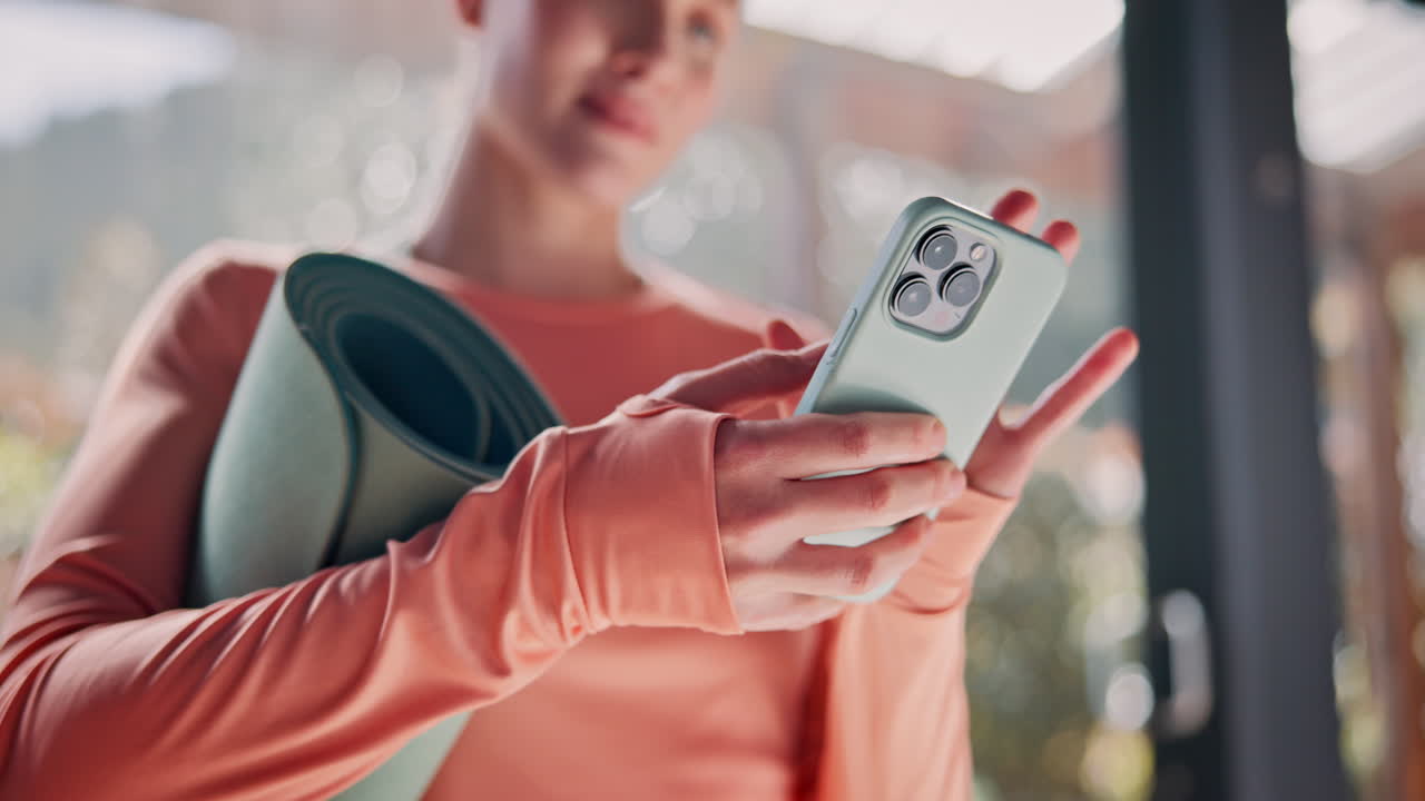 요가 운동 을 준비 하는 동안 전화 를 사용하는 여자