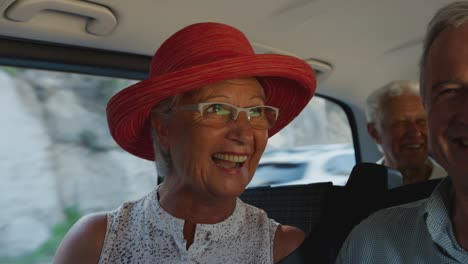 group of senior friends sitting in back of people carrier being driven to vacation