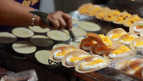 vendor prepares thai crispy pancakes at floating market