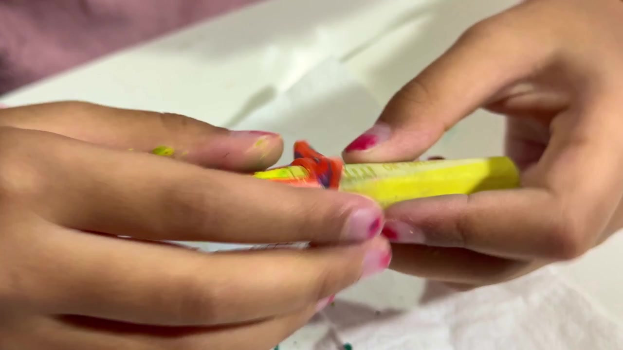 Kinderhände ziehen die Verpackung von einem Buntstift ab, Vorbereitung von Malutensilien, Konzept für Kinderkreativität und Malen