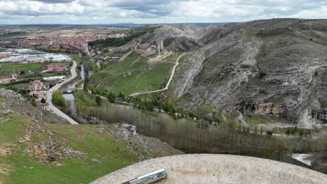 vuelo aéreo de aviones no tripulados hacia adelante sobre una torre de vigilancia con un castillo medieval y el pueblo medieval de burgo de osma en la parte posterior