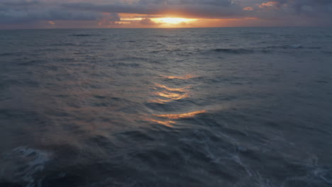 Aerial-dolly-shot-of-blue-sea-waves-during-golden-sunset.-Orange-and-blue-evening-shot-of-waves-at-sea