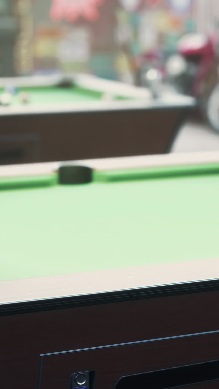 Close-up view of a green felt pool table with a blurred background
