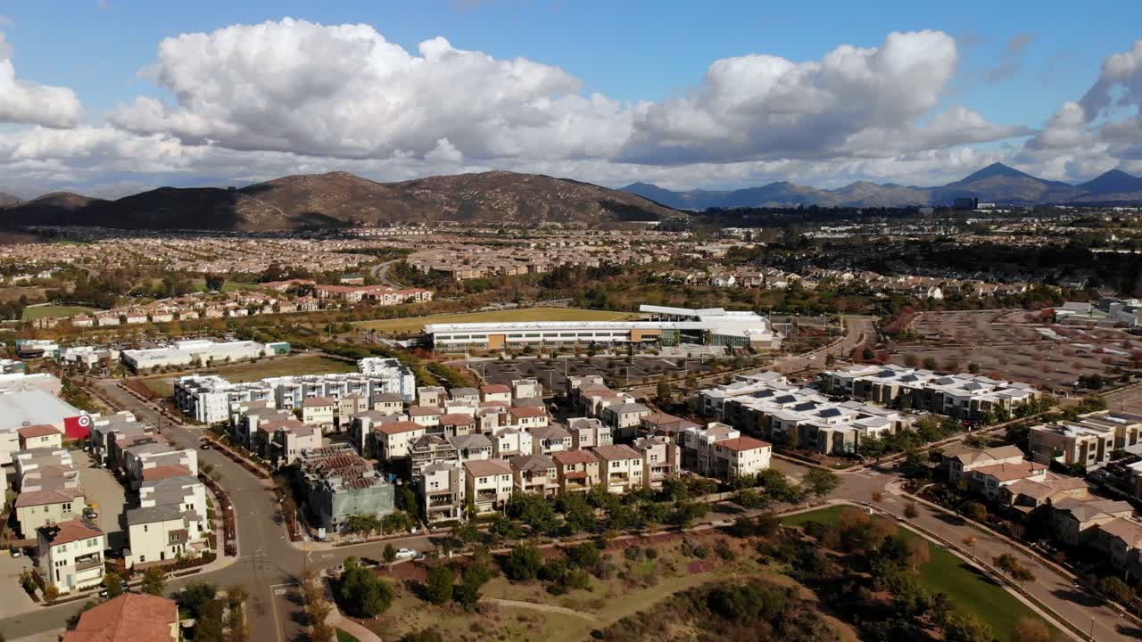 rotación aérea de alto nivel sobre la comunidad suburbana después de una lluvia que muestra escuelas y áreas comerciales