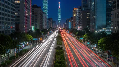 captivating nightscape of urban life: glowing traffic flowing through city streets beneath towering skyscrapers bathed in neon lights against a dark sky