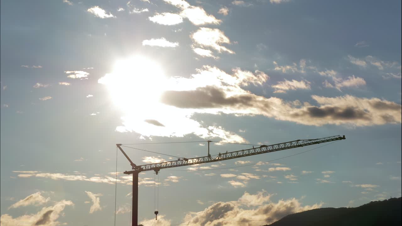 Time lapse of flying cloudscape during sunset at blue sky in background of industrial crane