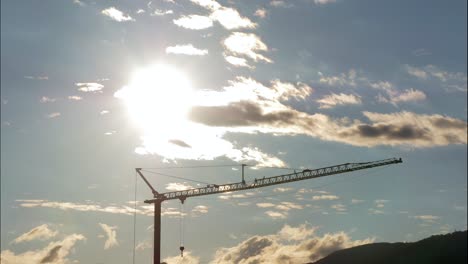 time lapse of flying cloudscape during sunset at blue sky in background of industrial crane