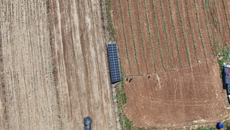 solar-panels-between-fields-zooming-out