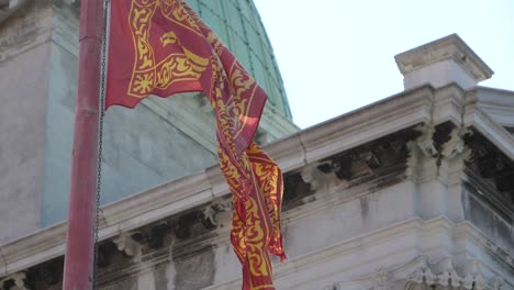 Cámara-Lenta-De-La-Bandera-Que-Sopla-En-La-Brisa-Con-La-Iglesia-En-El-Fondo,-Venecia