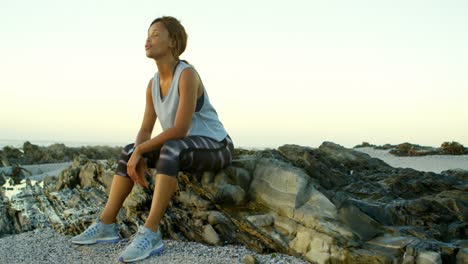 woman relaxing on rock at beach 4k