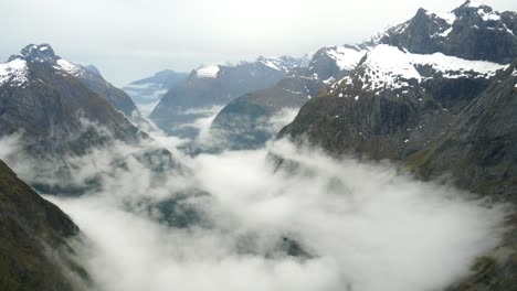 Captura-De-Timelapse-De-La-Naturaleza-Que-Captura-El-Paisaje-Salvaje-Del-Sendero-Gertrude-Saddle-En-El-Parque-Nacional-Fiordland-Con-Una-Espectacular-Formación-De-Nubes-Entre-El-Valle-Rocoso-Durante-La-Temporada-De-Invierno-Fría-Y-Nevada