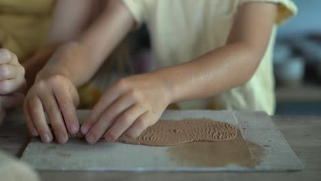 a young woman and her little son on a pottery master class