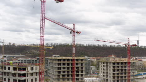 Grúas-Torre-Rojas-Trabajando-En-El-Sitio-De-Construcción-En-Praga,-Día-Nublado