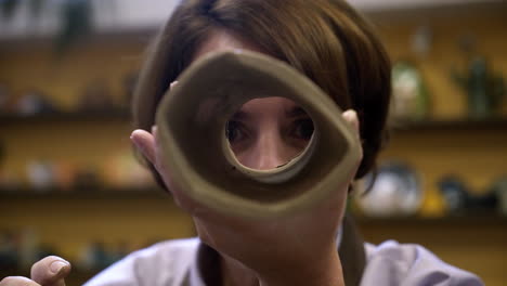 woman examining clay tube