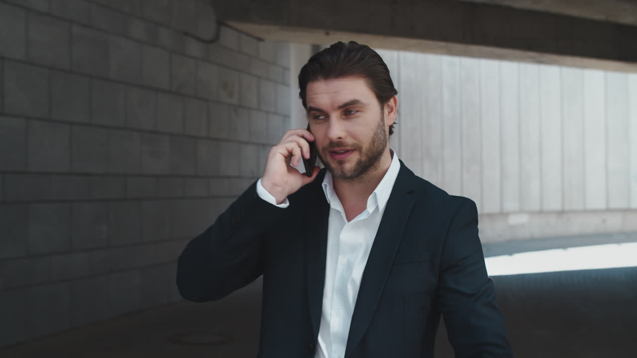 Businessman calling on cellphone at street. Manager checking time on wristwatch