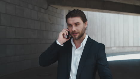 businessman calling on cellphone at street. manager checking time on wristwatch