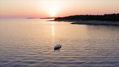 aerial shot circling a boat at sunset off the coast of losinj island, croatia