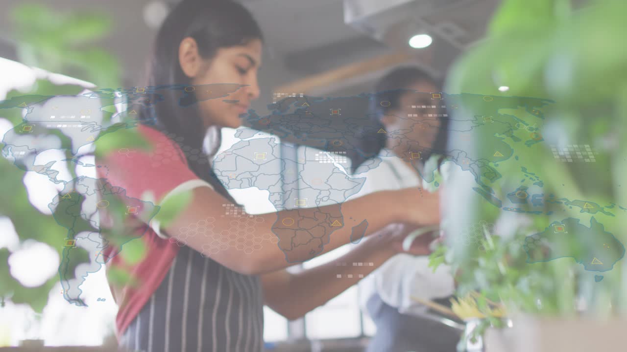 Pulling back showing teen girl snipping cilantro as colleague mirroring trimming for culinary prep