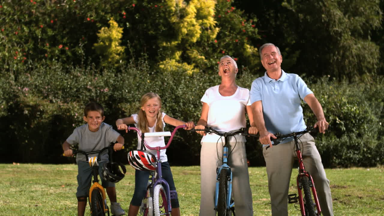 familia multigeneracional posando en un parque con sus bicicletas