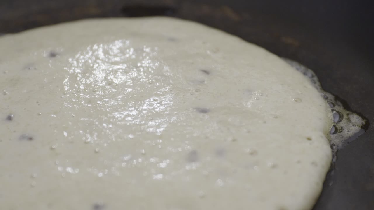 Close up of pancake cooking. Bubbles in the pancake batter as it cooks