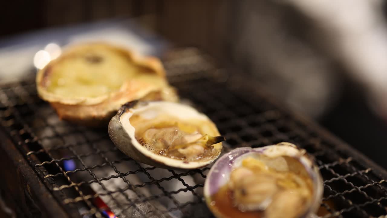 Scallops and crab cooking on a charcoal grill