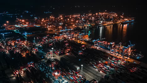 puerto de envío, barco de contenedores de carga, grúa y tráfico de automóviles en la ciudad moderna al atardecer nocturno