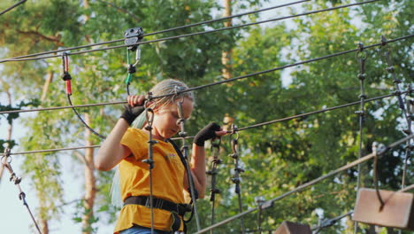 a child climbs ropes high in the trees - having fun in a rope city in an amusement park