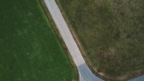 Aerial-drone-shot-slowly-zooming-in-on-motorcyclist-on-a-moped