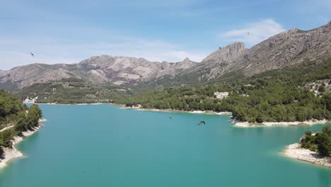 Impresionante-Hermoso-Lago-Azul-Turquesa,-Pájaros-Volando-Y-Cielos-Soleados