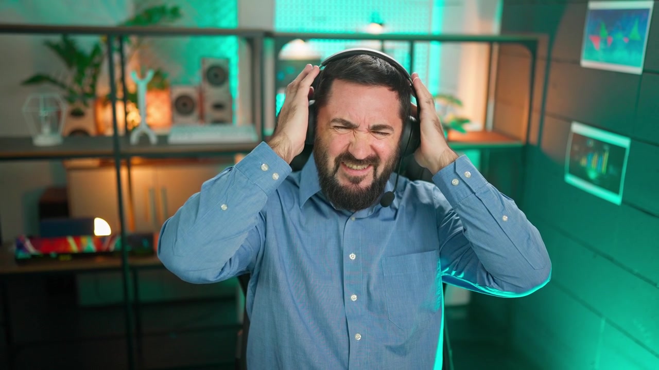 Uomo frustrato con l'auricolare che reagisce a cattive notizie o al rumore