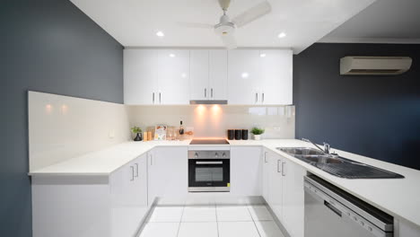 white modern renovated kitchen apartment with cooking area and new stainless steel appliances