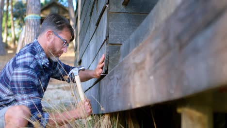 hombre martillando una tabla de madera con un martillo 4k