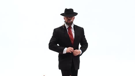 man in suit and hat posing and sitting in studio