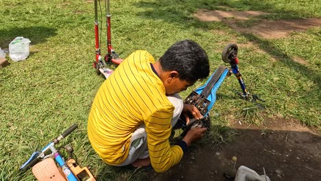 El-Hombre-Asiático-Repara-La-Bicicleta-De-Los-Niños-En-El-Jardín