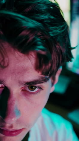 close-up of a person at a computer desk at night.
