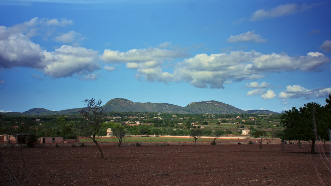 este lapso de tiempo captura la belleza de una montaña contra un cielo azul claro mientras las nubes blancas se desplazan y emergen nuevas formaciones
