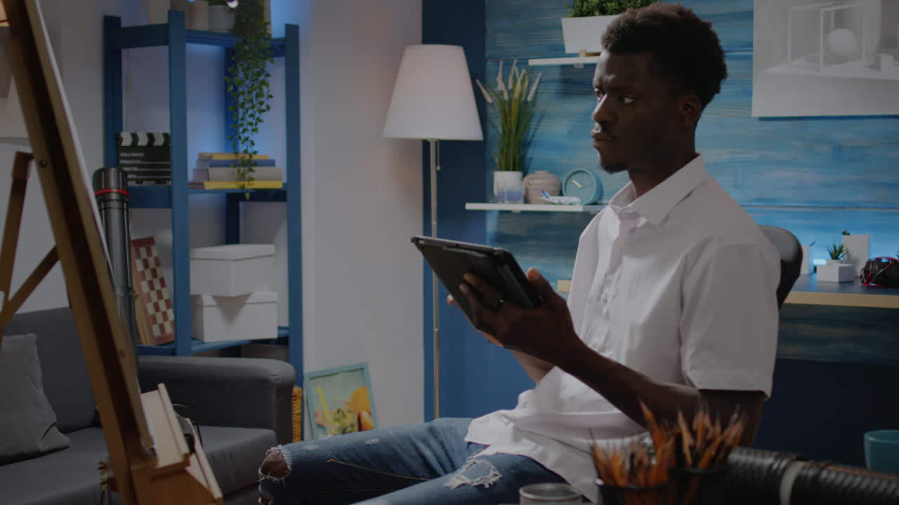 African american artist using digital tablet in artwork studio