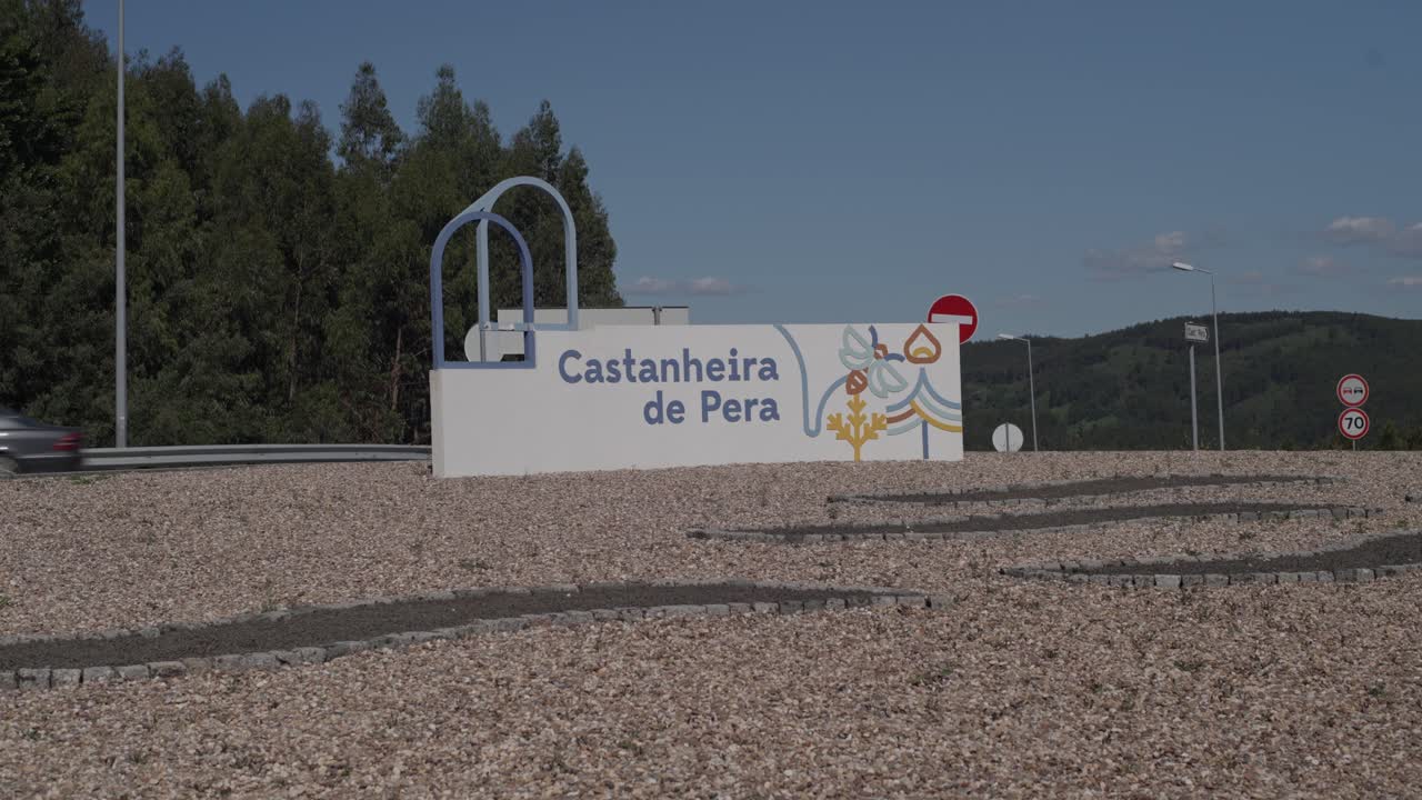 Placa de entrada da cidade de Castanheira de Pera ao lado da paisagem rodoviária.