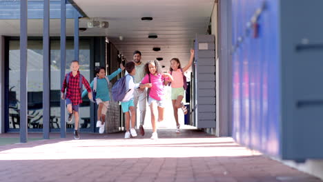 in a school corridor, a diverse group of young students is running