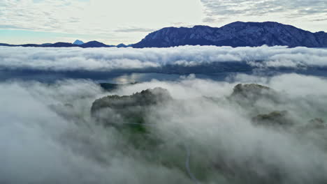 Aerial-view-of-the-fog-covered-countryside-at-lake-Attersee,-fall-day-in-Austria